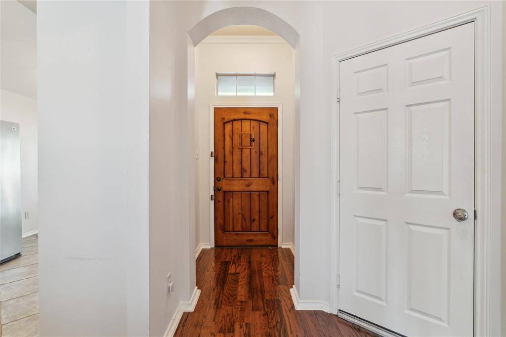 Upon entry, you're welcomed by a charming foyer featuring an elegant arched entryway that sets the tone for the rest of the home.
