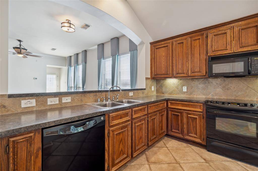 The kitchen offers abundant cabinetry for ample storage and features a large arched opening that creates a seamless connection to the formal dining and living areas—perfect for both entertaining and everyday living.