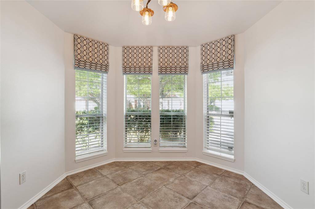 Enjoy a charming view of the front yard from the breakfast area, complete with a custom chandelier that adds a touch of elegance to your morning routine.