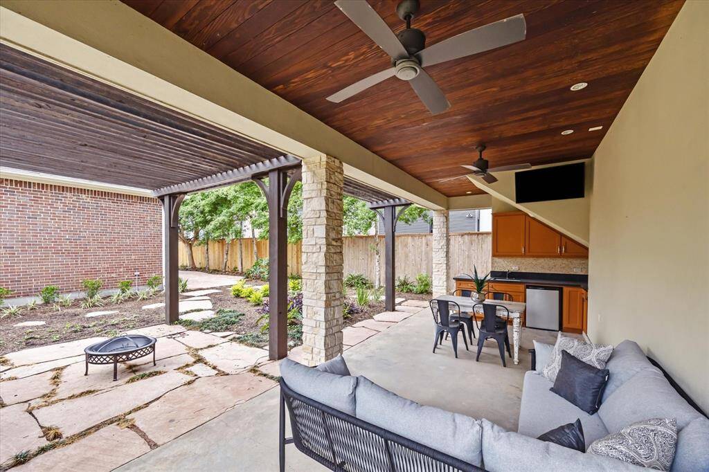 This photo showcases a bright, open-concept living space with elegant wooden flooring and a central winding staircase. Large windows and arches enhance natural light, while the dining area features modern decor and art.