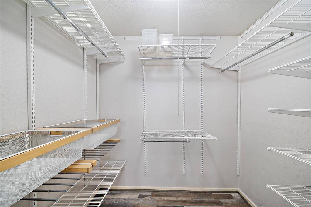 Walk in closet with convenient storage organizers in master bedroom.