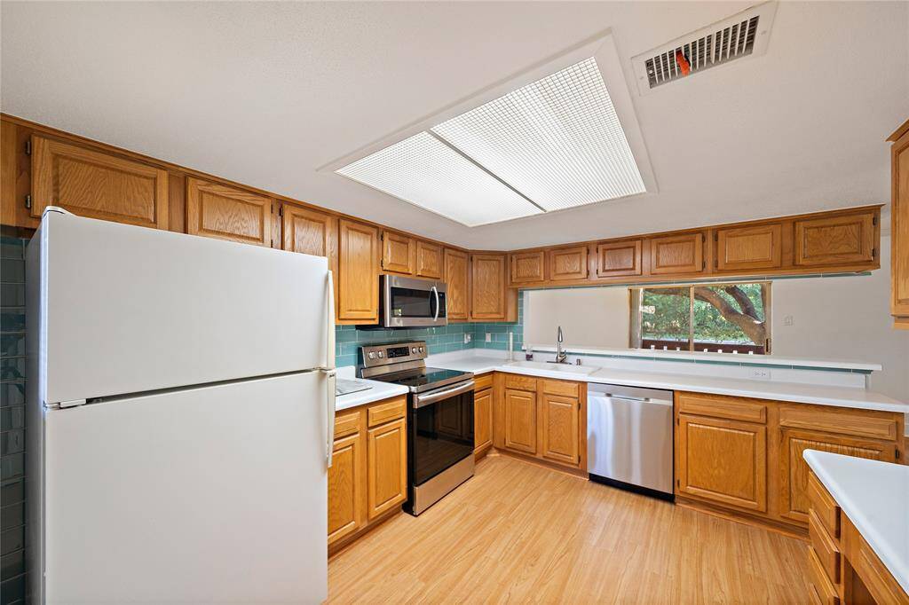 Kitchen features stainless steel appliances and has plenty of countertop space.