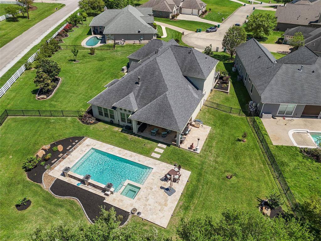 Exceptional lot with geometric pool, water features, hot tub, expansive patio, generator, fully fenced, with gutters.