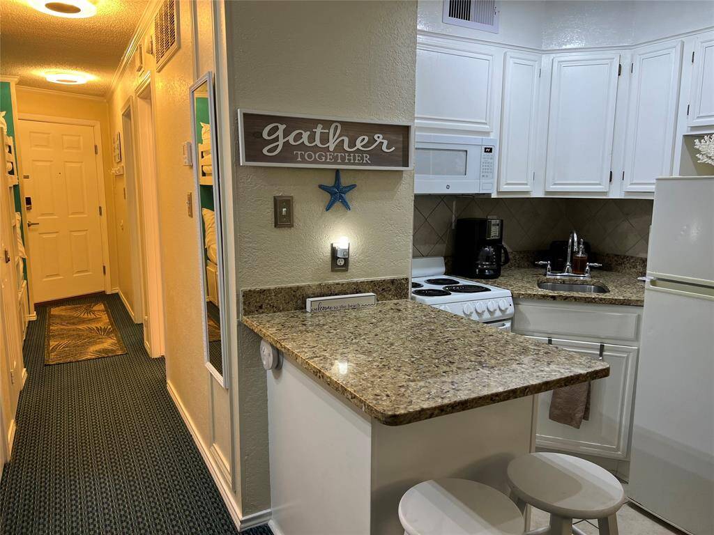 Another view of kitchen and hallway
