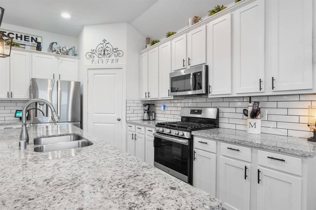 Luxury granite countertops throughout the home with large modern subway tiles.
