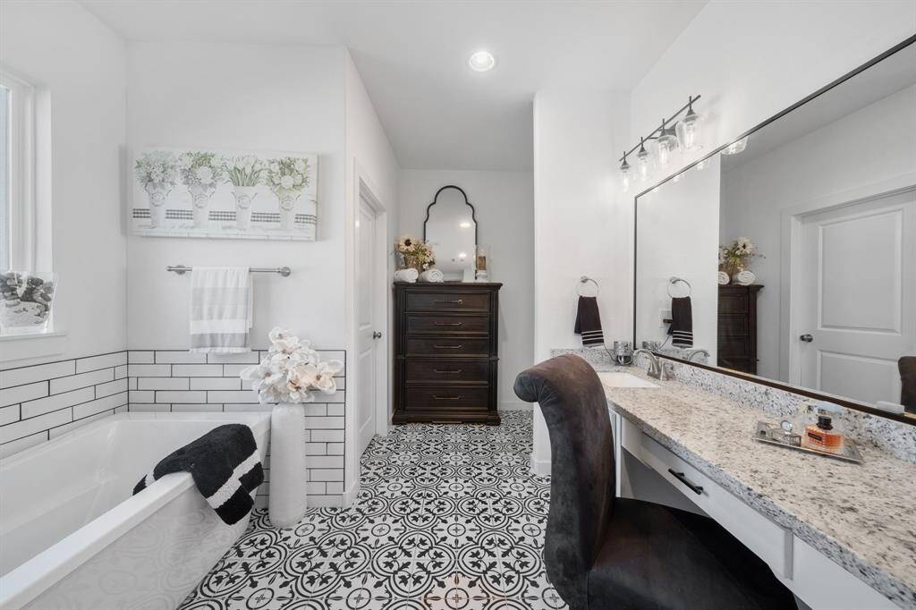 This luxurious custom bathroom is a dream from the tiled flooring to the large soaking tub.