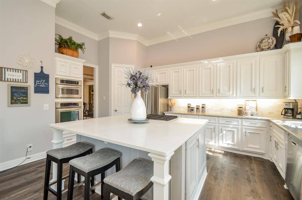 Large island with breakfast bar, quartz countertop, microwave drawer, pull-out storage drawers, and outlets with USB ports.