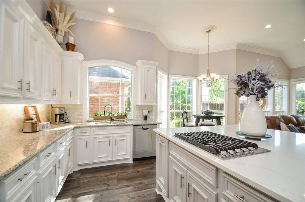 Gas cooktop, custom built cabinets, and under cabinet lighting.
