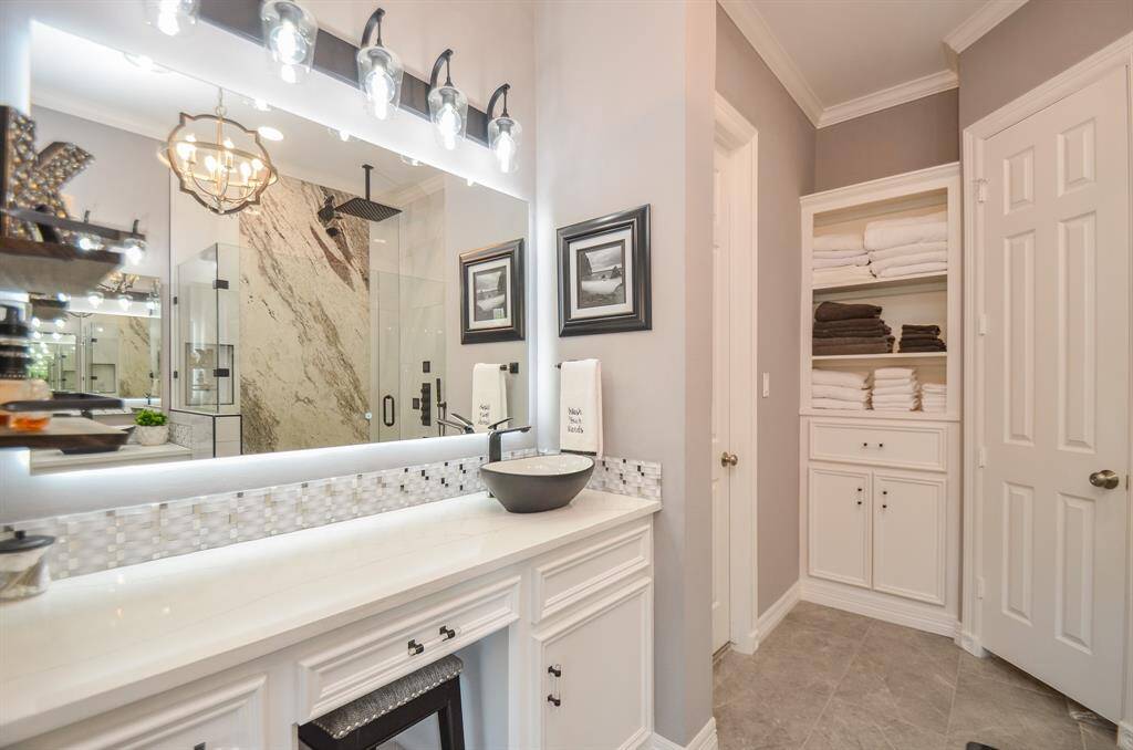 Classy quartz countertop and seated makeup vanity with backlit LED mirror.