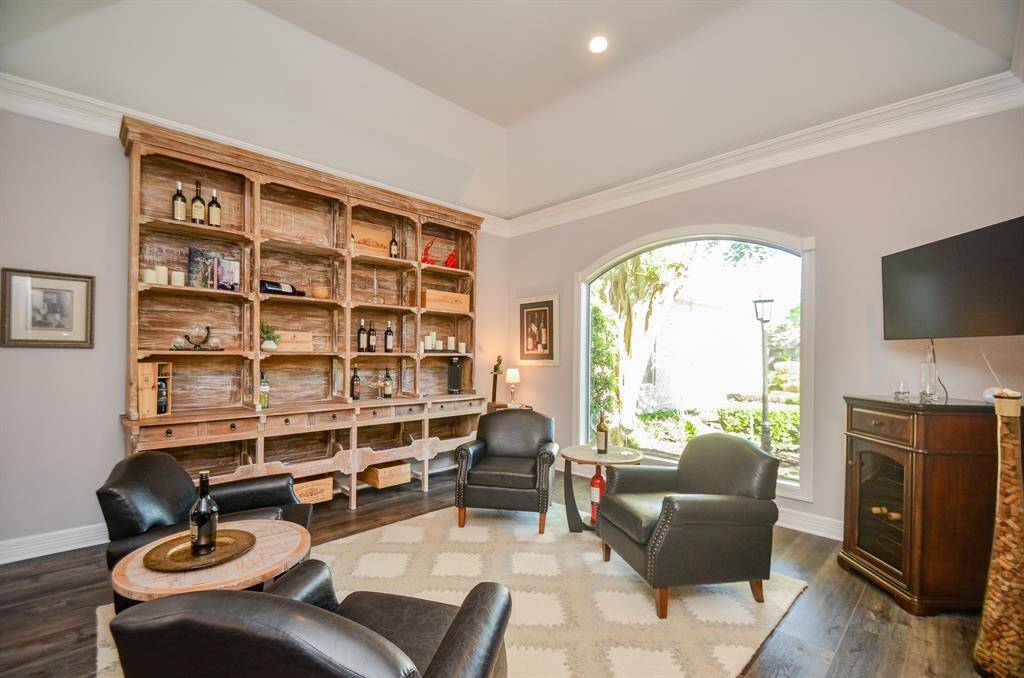 Formal living room, currently used as a wine room, features a stunning picture window and raised ceiling with accent lighting. This room could also serve as a study.