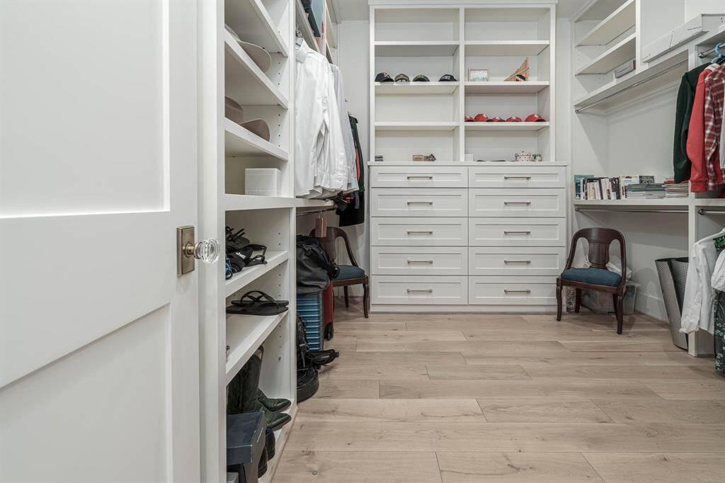 spacious, organized walk-in closet with ample built-in shelving, drawers, and hanging space.