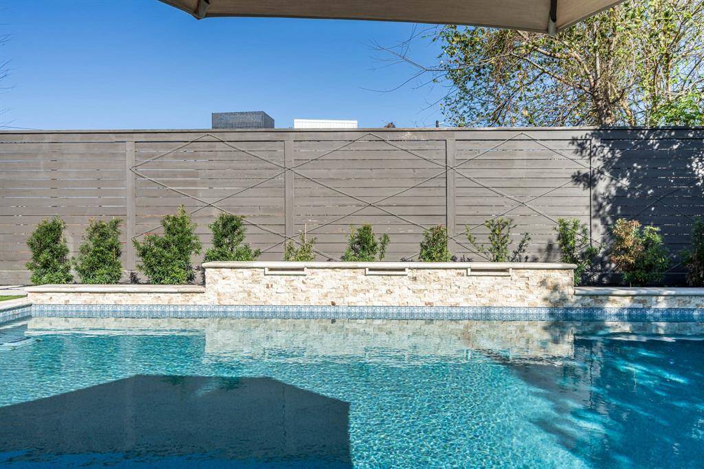 modern backyard with a sparkling swimming pool, landscaped greenery, offering a private and serene outdoor space.