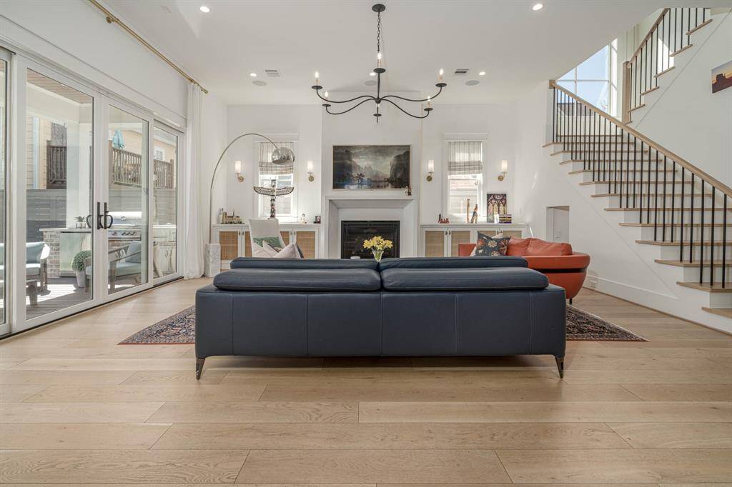 Large sliding glass doors open to a covered patio area, offering plenty of natural light. A contemporary staircase adds a stylish touch.