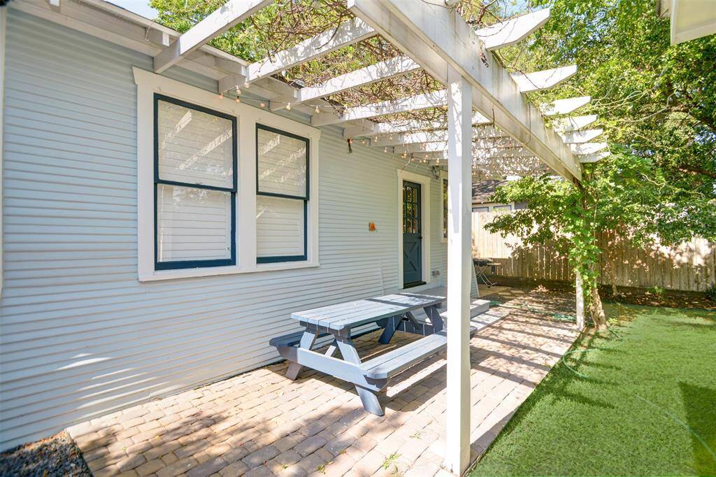 The backyard with wisteria covered patio and seating area