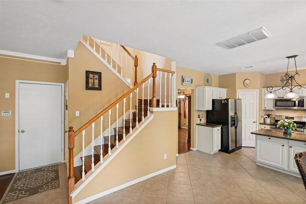 Gorgeous split level wooden staircase leads to the recently carpeted upstairs.