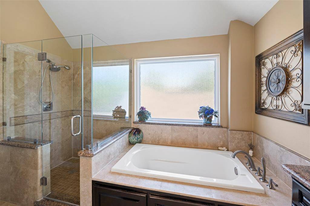 The primary bathroom with beautiful tile and granite.