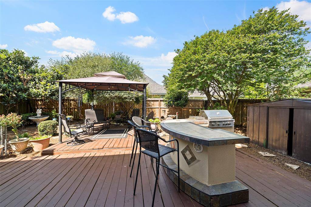 Outdoor kitchen w/ grill, refrigerator & stereo, hot tub, fire pit, & decorative pond.