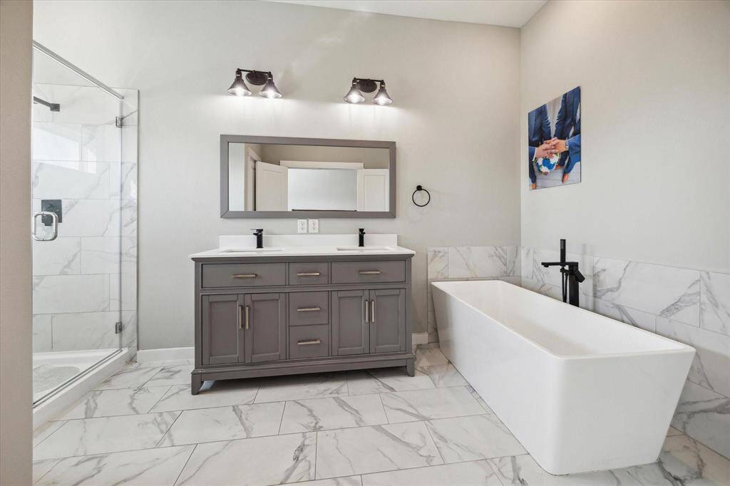 Primary bedroom en suite with soaking tub, double sinks, and separate shower.
