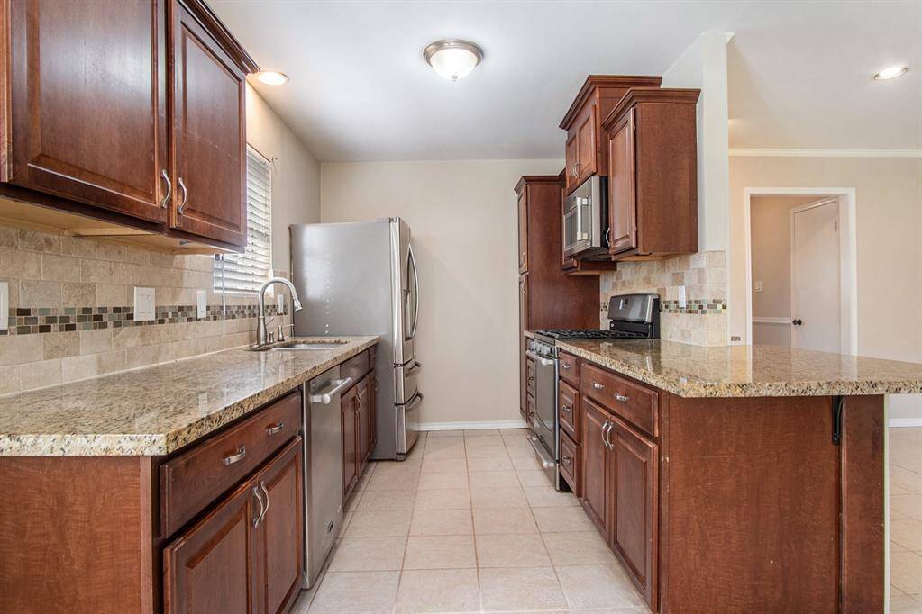 Galley kitchen with granite countertops.