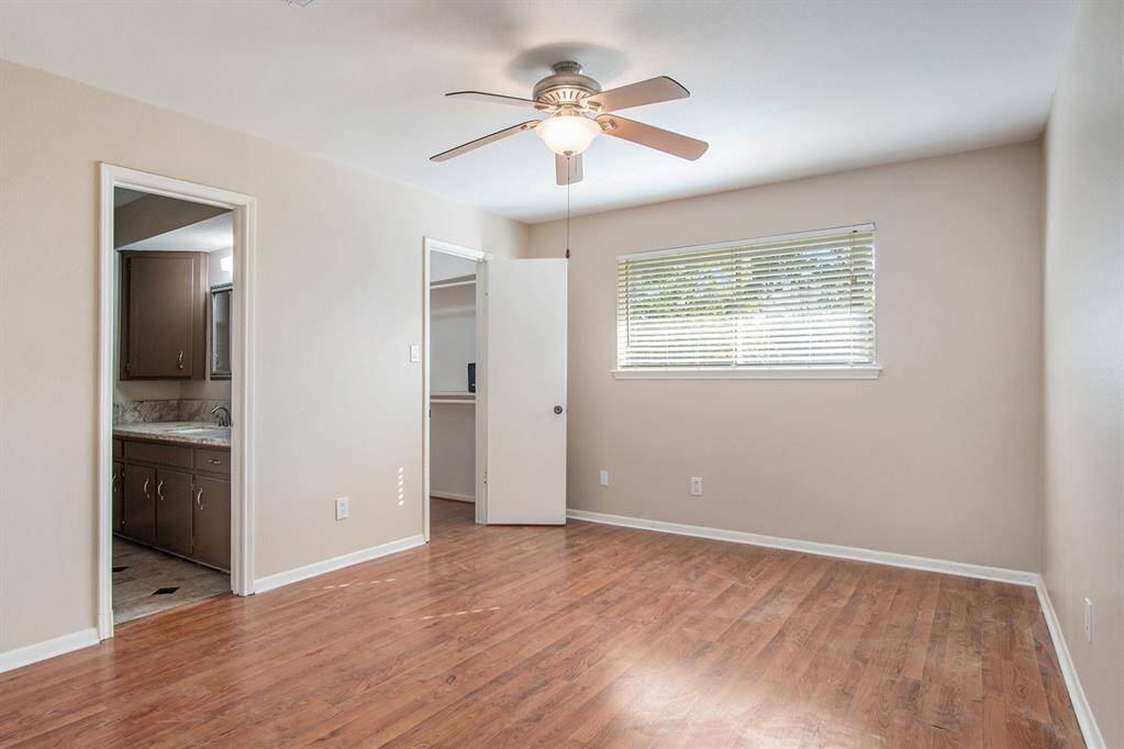 Primary bedroom provides natural light, updated bathroom and walk-in closet.