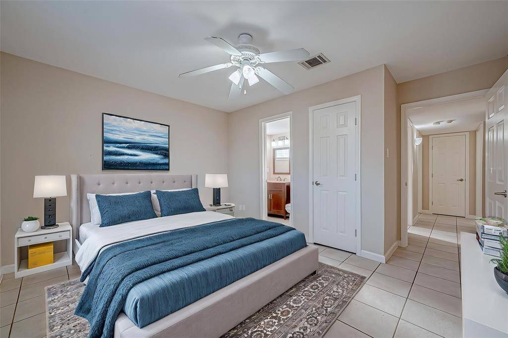 The primary bedroom is bathed in sunlight and boasts an ensuite half-bath. *Virtually Staged*