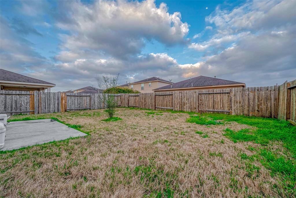 A vast outdoor space with endless potential, enclosed by a wooden fence for added privacy. The open grassy area is perfect for play, gardening, or future outdoor additions.