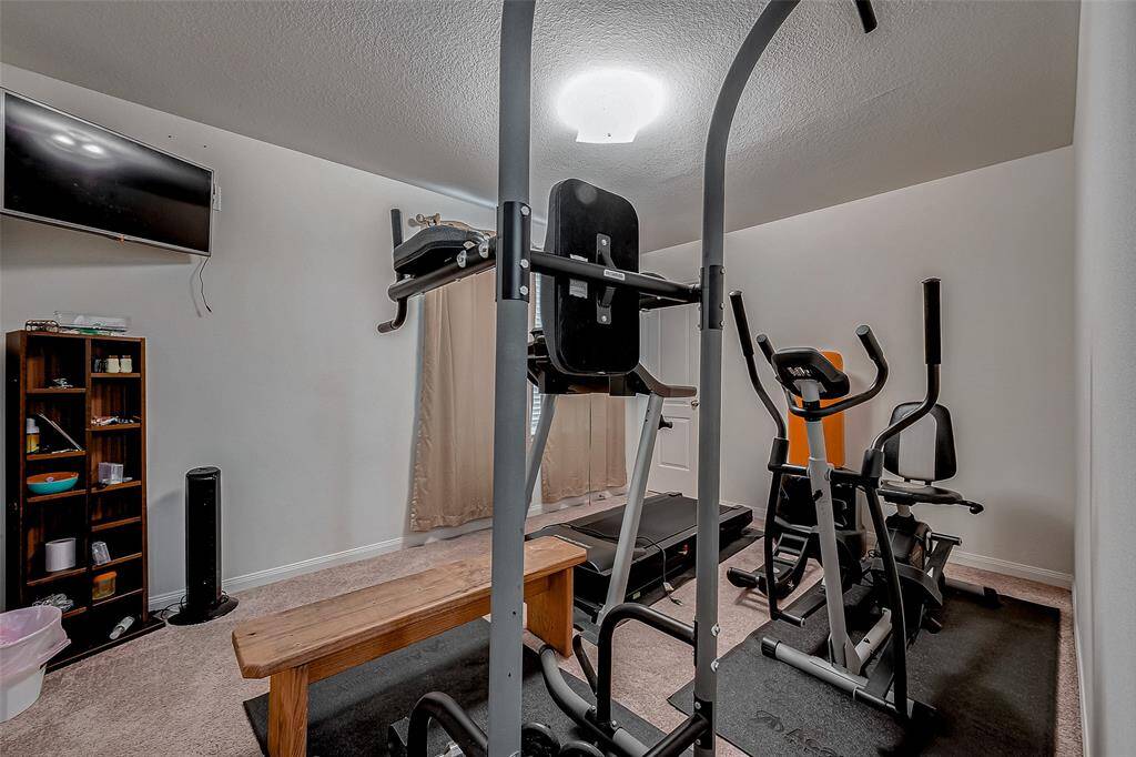 Another well-sized bedroom with soft carpeting and a neutral palette, easily adaptable for a guest room, exercise space, or personal retreat.