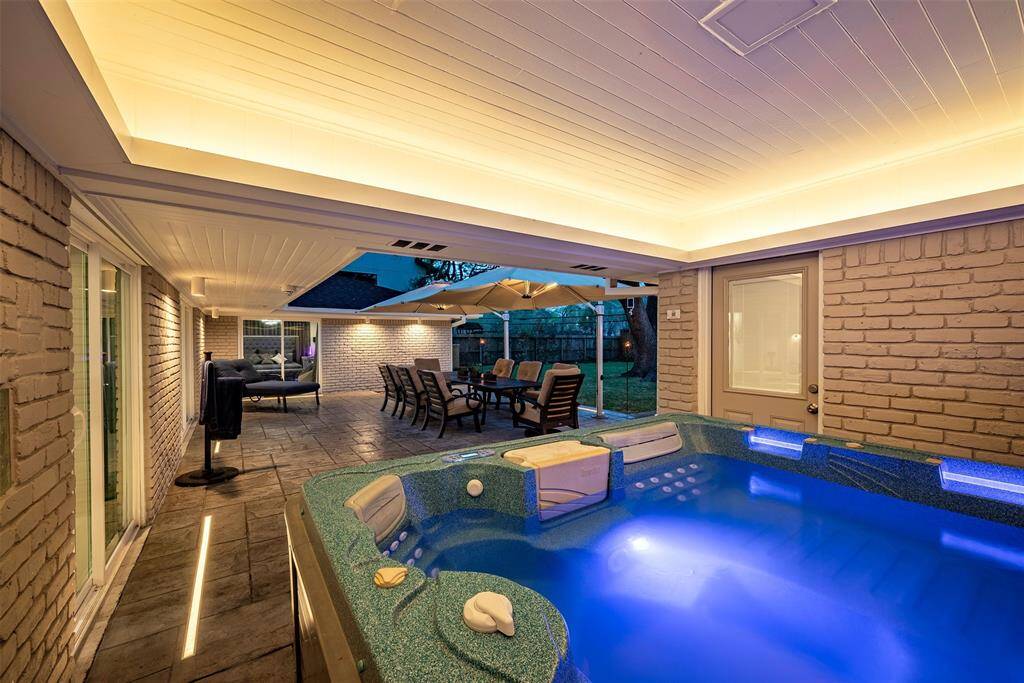 Relax in style with this luxurious hot tub featuring ambient custom lighting and an elegant shiplap ceiling.
