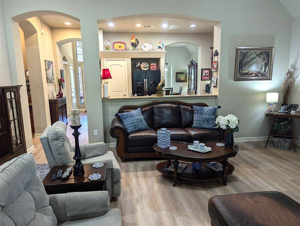 Living room with a view into the kitchen. Notice the arches throughout!