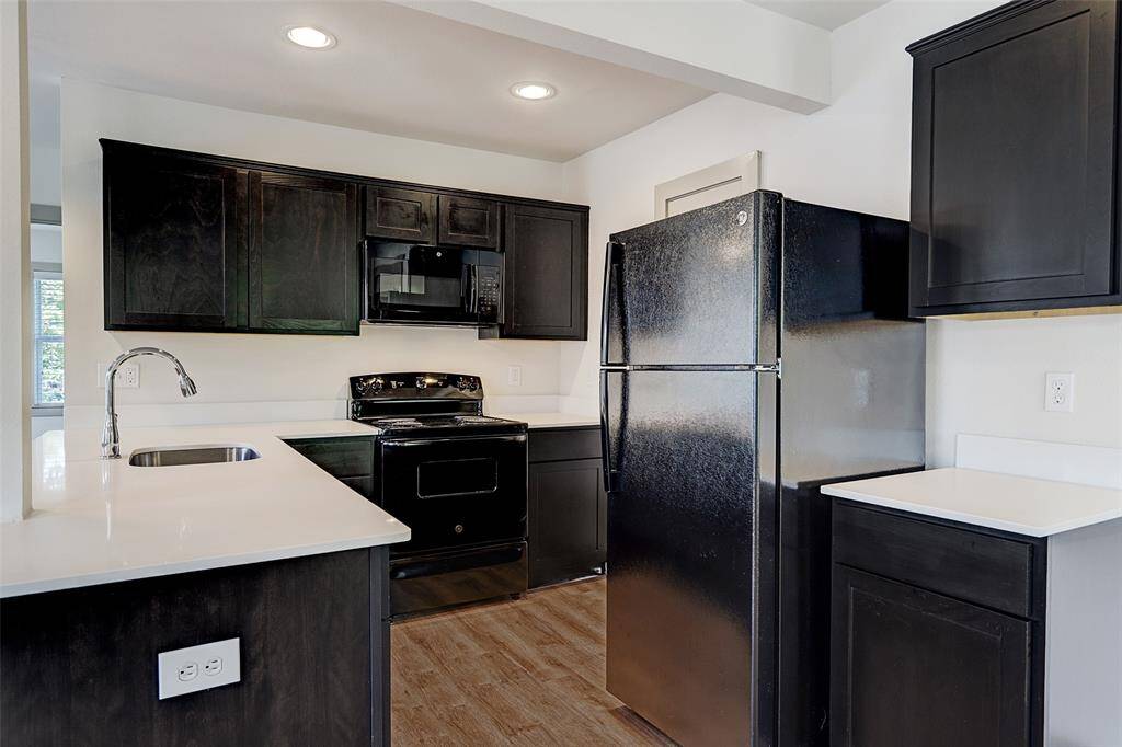 LARGEST Fourplex - Lovely kitchen features; white quartz counter tops, brand new electric stove and oven, new refrigerator, microwave and dishwasher!