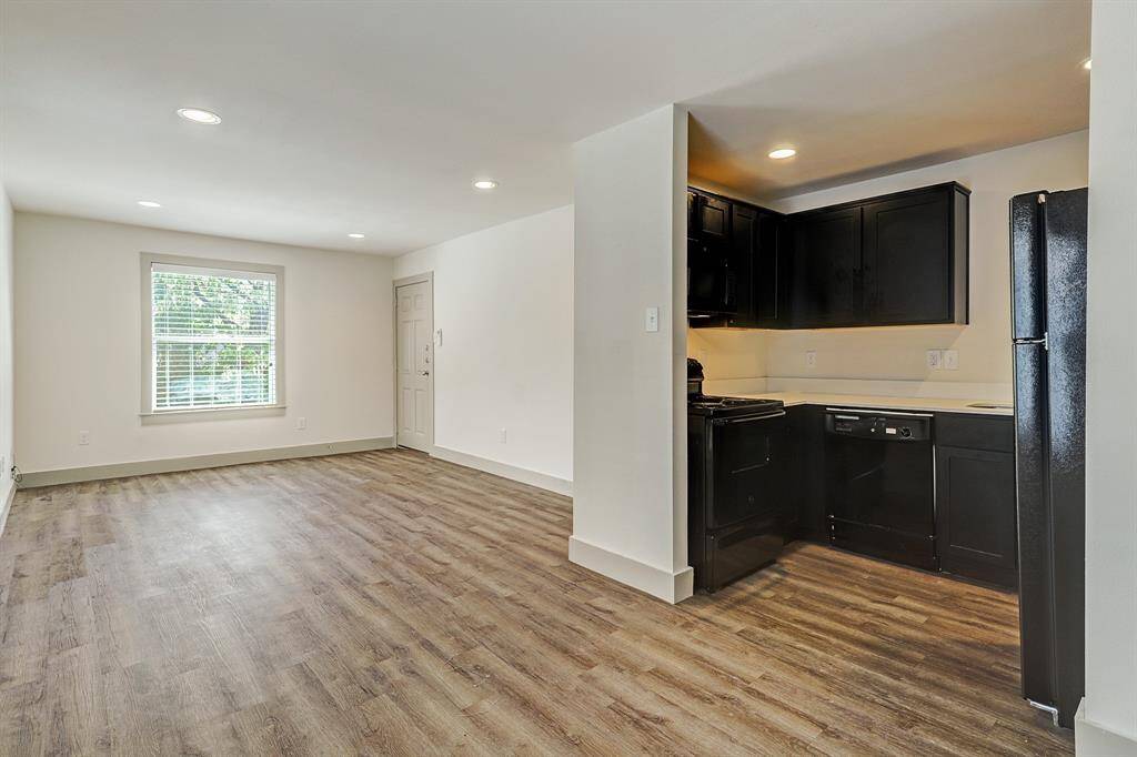 SMALLER FOURPLEX -Beautiful updated space with tons of natural light! Right: Partial view of cutout kitchen with dishwasher, stove, oven...updated quartz counter tops with ample counter space.