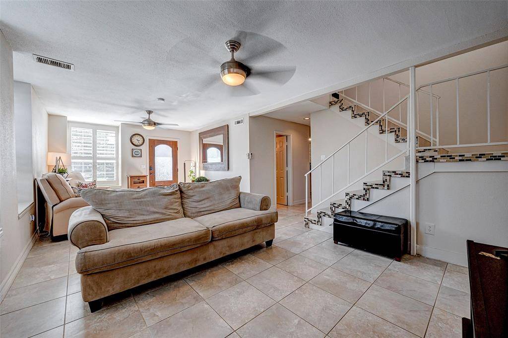 Natural light streams in through large windows, enhancing the spacious feel. A stylish staircase adds a modern touch, leading to an open, airy layout perfect for relaxation or entertaining.
