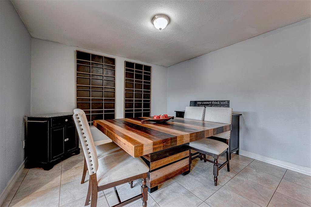 A cozy dining area, the room has tile flooring, neutral walls, and built-in shelving, creating a warm and inviting atmosphere.