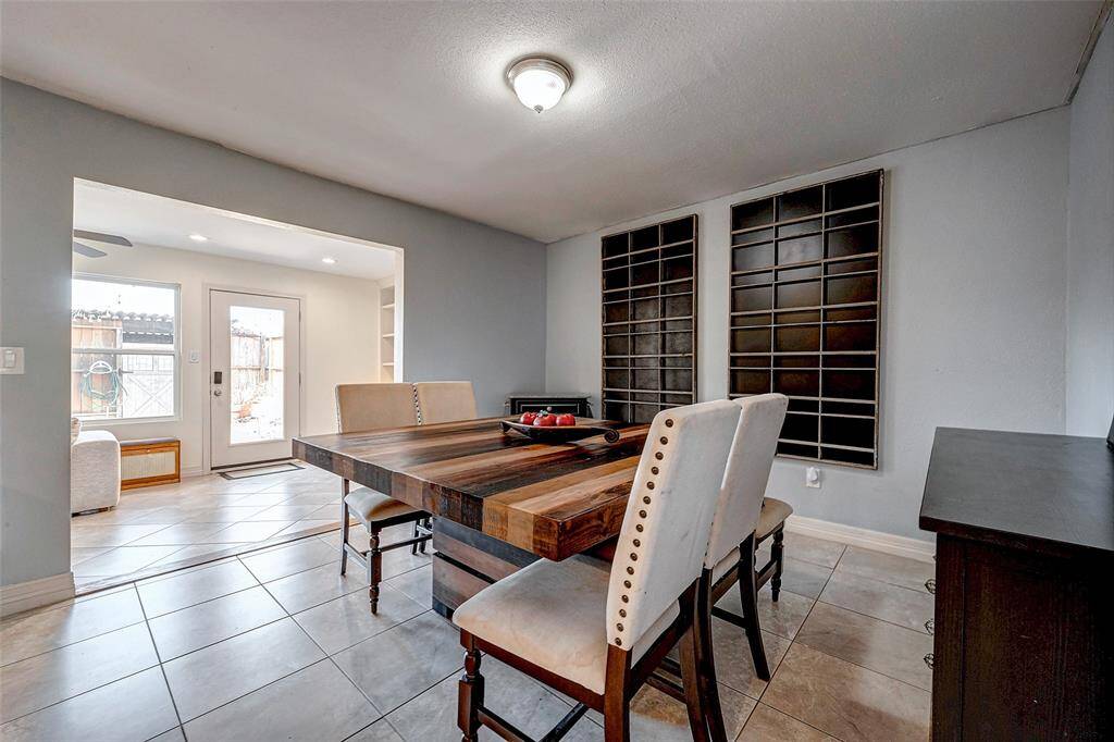 The space is tiled and opens to a bright room with natural light from a door and window, creating an inviting atmosphere.