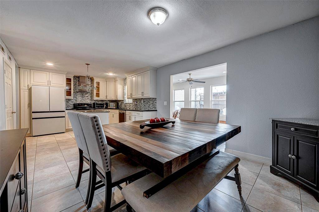 The open layout leads to a bright adjoining room with large windows, enhancing the airy and inviting atmosphere.