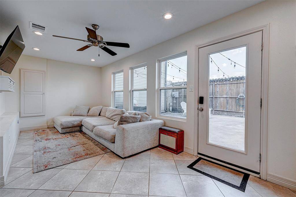 Cozy living extension to add sqft to your property. Ample natural light comes through multiple windows and a glass door that leads to a fenced patio. Ideal for relaxation and indoor-outdoor living.