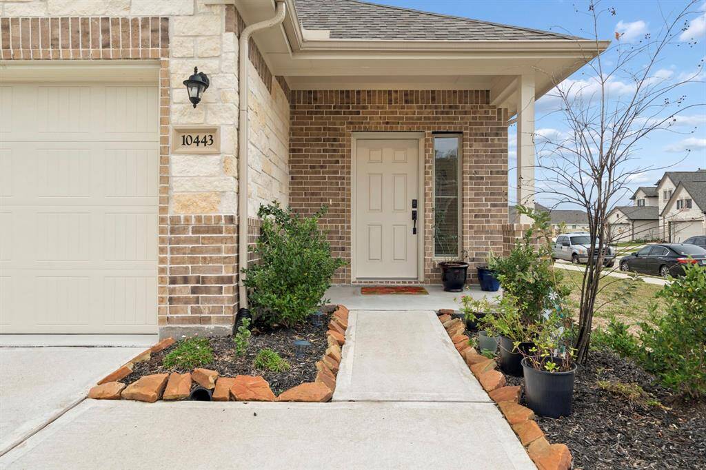 The property boasts stunning landscaping and a charming covered entrance, offering an inviting and picturesque entryway.