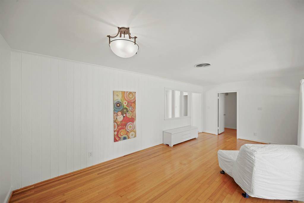 The Dining Area features Oak Hardwood Floors, Fresh White Designer Paint, and a Treated Metal Chandelier with Opaque Glass Dome Shade.