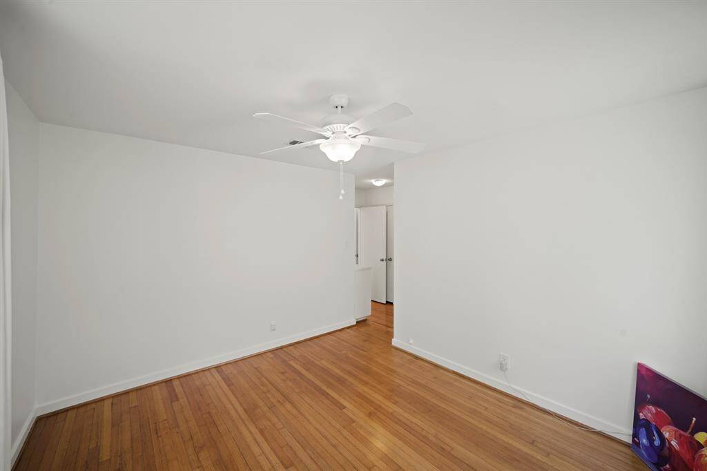 The Primary Bedroom offers Oak Hardwood Floors, Fresh White Designer Paint, and a White Ceiling Fan with Opaque Glass Shade and Light.