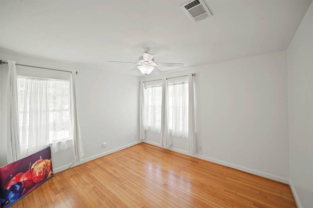 A Rear Window in the Bright Primary Bedroom views the Park-Like Backyard.