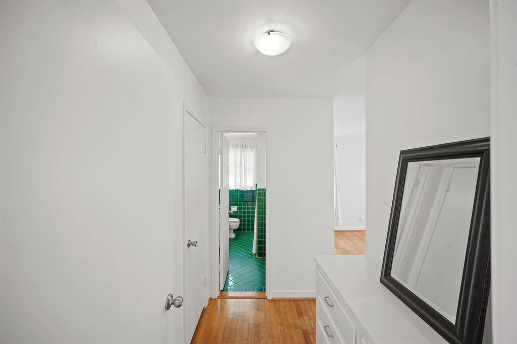 The Primary Suite offers the Convenience of a Dressing Area that features Oak Hardwood Floors and a Built in Dresser with 8 Drawers---How Great is That!
