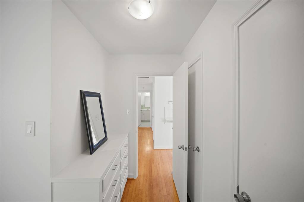 Additional Amenities in the Primary Bedroom Dressing Area include 2 Closets with a Hanging Rodand Built in Shelf, Flush Mount Light Fixture, and Fresh White Designer Paint.