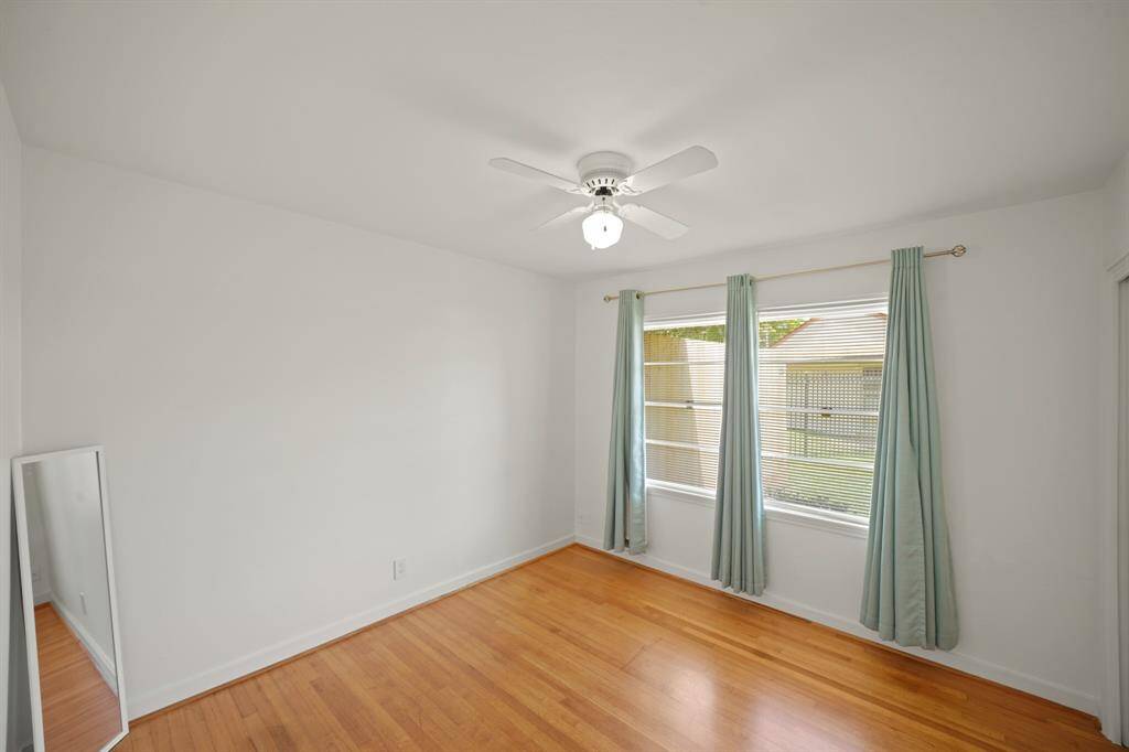 The Second Bedroom features a Picture Sized Window that views the Side Yard and Sage Teal Linen Style Window Coverings.