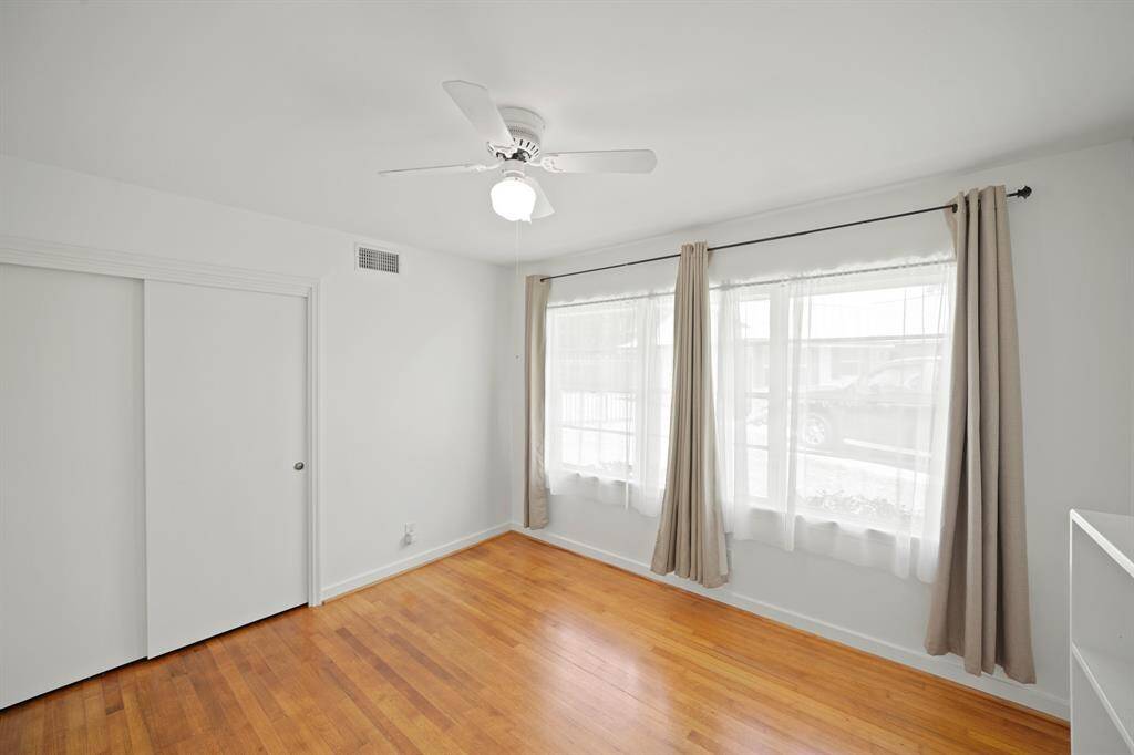 Additional Amenities in the Third Bedroom include Oak Hardwood Floors, Fresh White Designer Paint, and a Closet with Hanging Rod, Built in Shelf, and 2 Panel Door Enclosure.