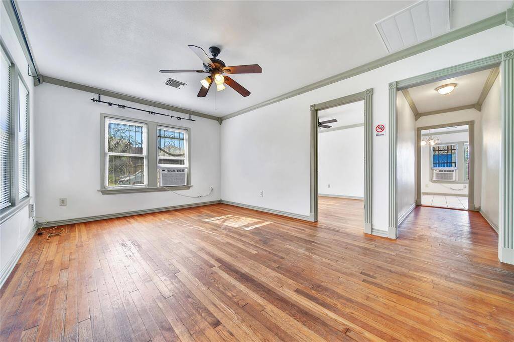 Living room (standing at front door) features hardwood floors, fresh paint and windows that allow in natural light.