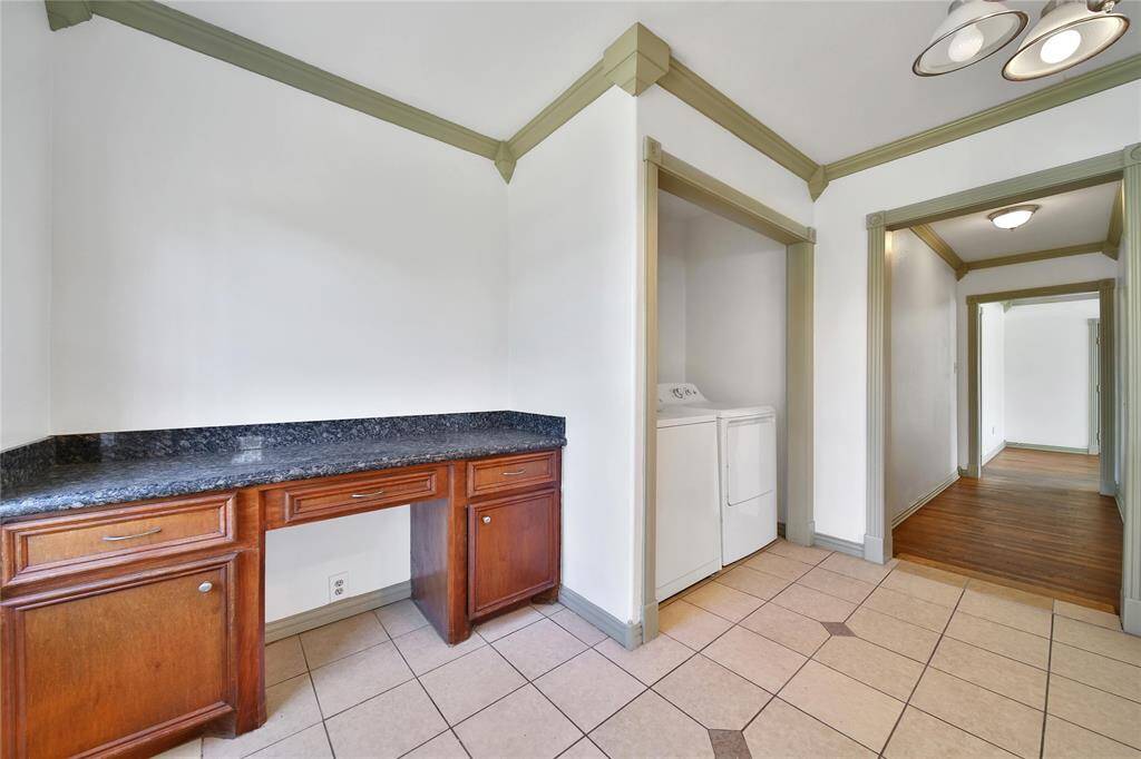 Washer/dryer located in the kitchen with extra workspace adjacent.