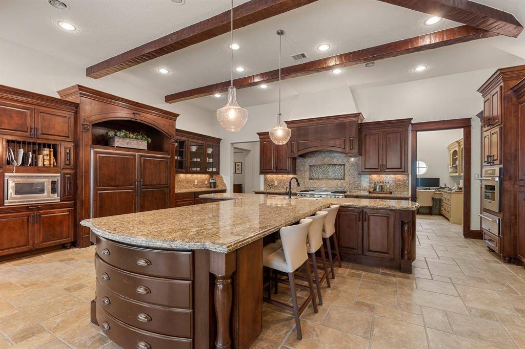 The kitchen boasts a spacious layout with a large island at its center, providing ample room for cooking, dining, and entertaining.