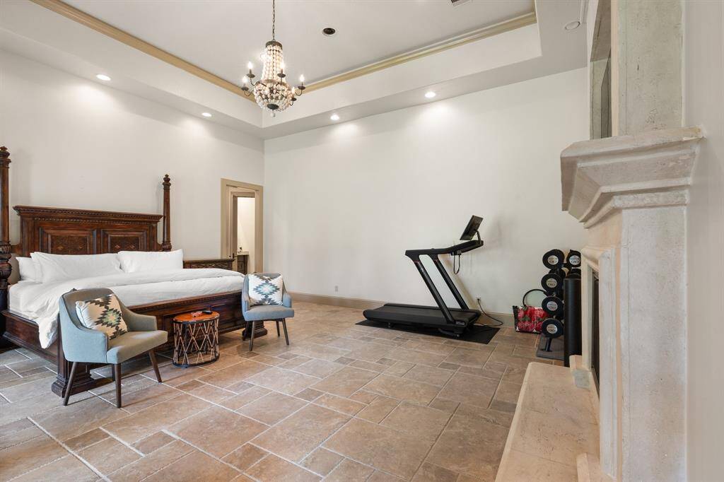 Step into the opulent master bedroom, where a regal king-size bed takes center stage beneath the glittering glow of a magnificent light, creating an atmosphere of luxury and grandeur.
