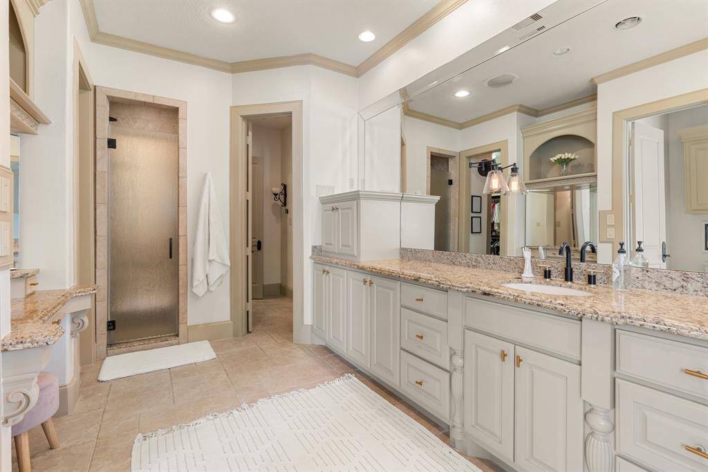 Along one wall, the vanity provides ample storage and counter space, with sleek countertops and modern fixtures that add a touch of elegance to the room.