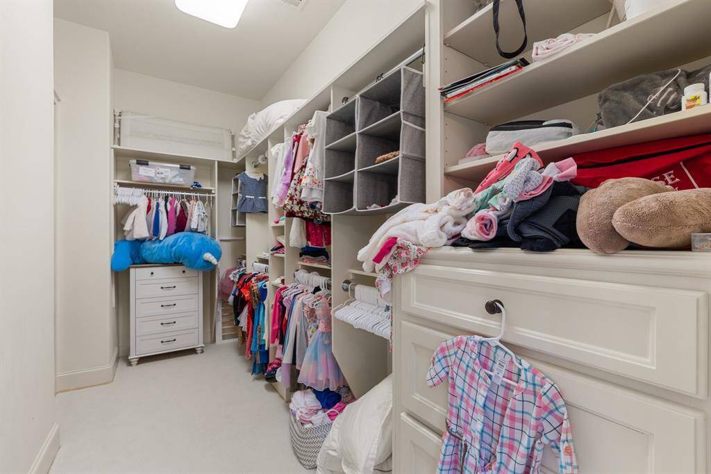 In this spacious and well-appointed walk-in closet, storage is abundant and style is paramount.